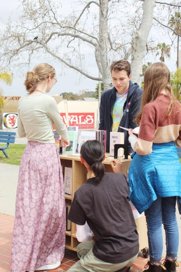 GSA Club hosts a pride festival in the quad with booths for students to check out. At this booth students read books by LGBTQ+ authors that are available in the library.