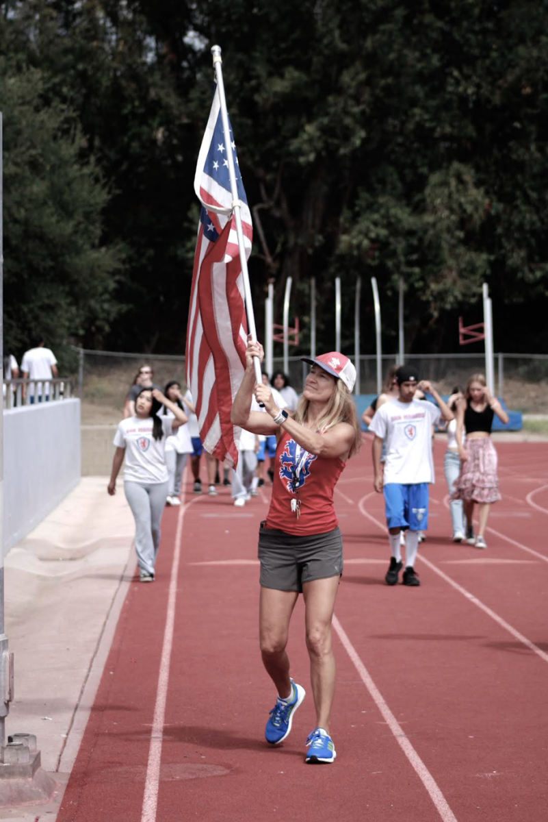 P.E. teacher Ms. Mandarino waves American flag during 9/11 commemoration