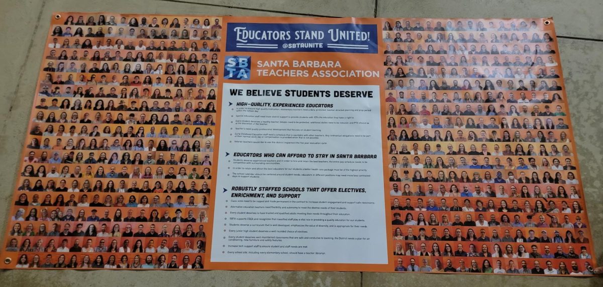 A large banner that has all union teachers faces, and list of requests