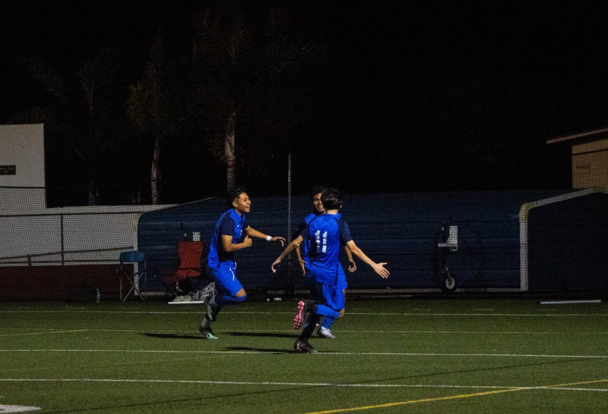 Royals soccer players celebrate a goal in their last game against rivals.