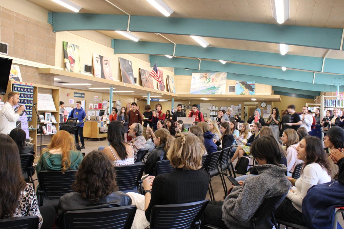Students and faculty gather in the library for the 2024 Poetry Slam.