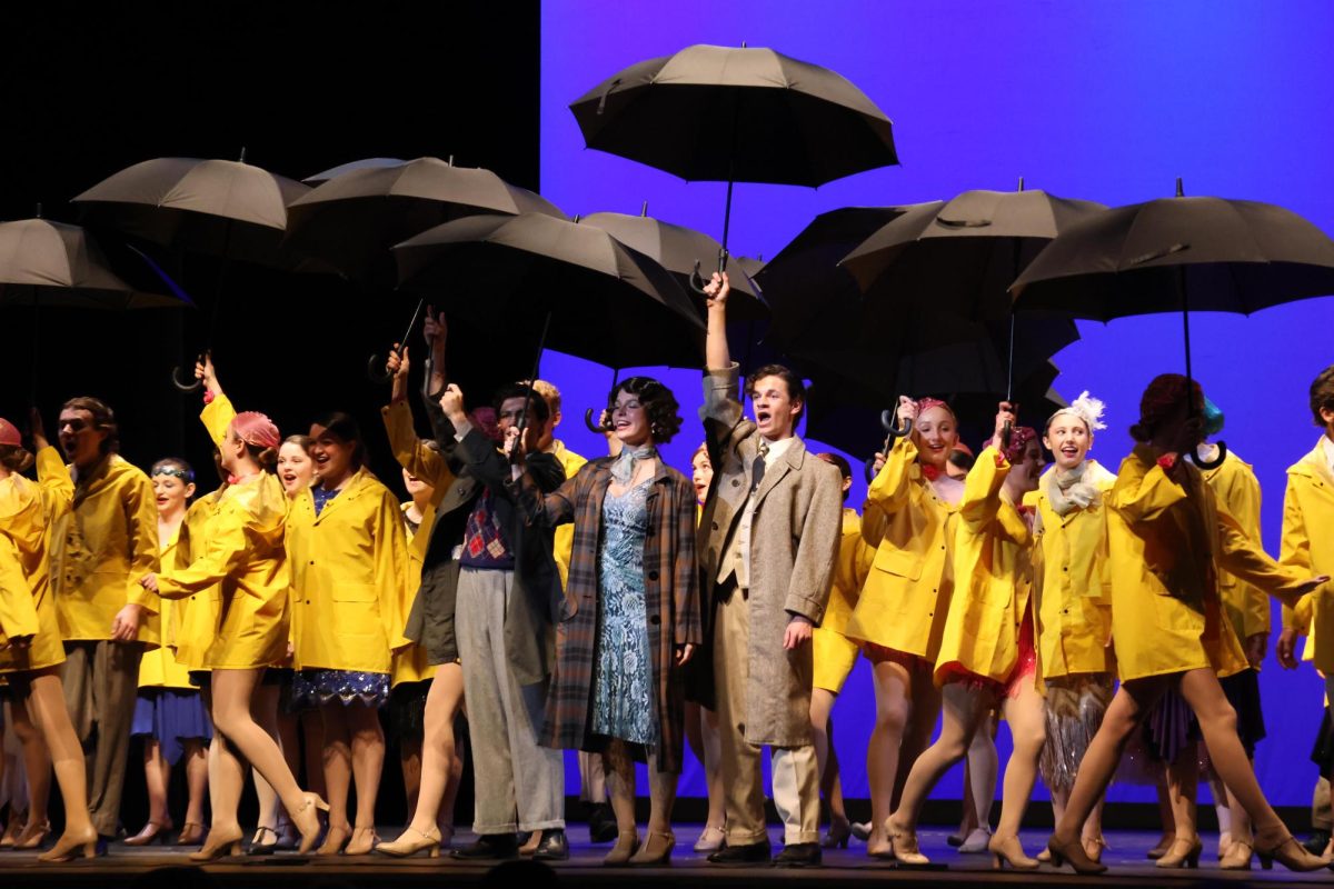 The cast of Singin’ in the Rain dawns the musical’s signature yellow rain jackets.

