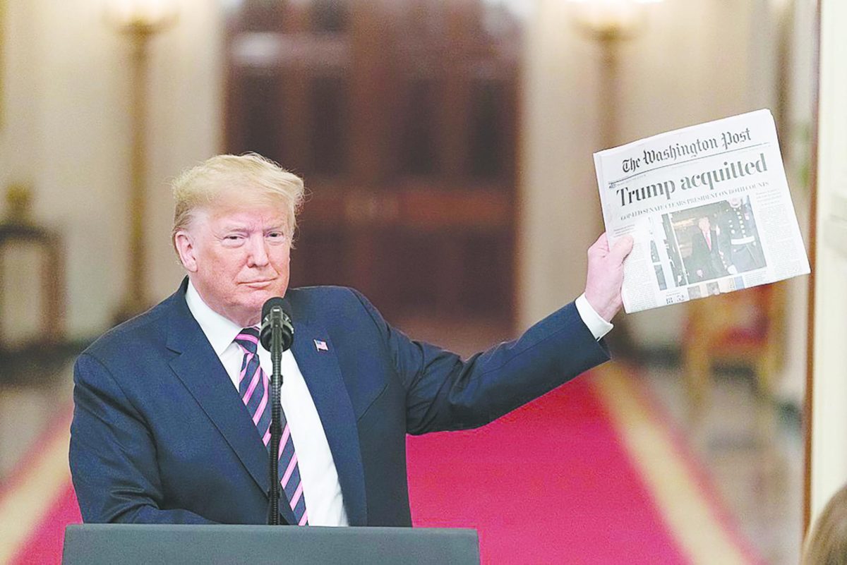 Trump holding a newspaper with the headline "Trump Aquitted"